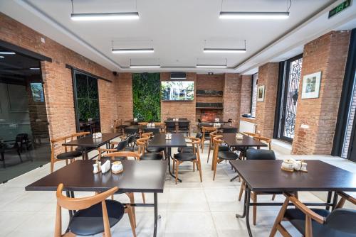 um restaurante com mesas e cadeiras de madeira e paredes de tijolo em Tiflis Hotel em Tbilisi