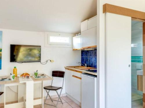 a small kitchen with white cabinets and a table at Très beau studio près de la mer aux Issambres in Les Issambres