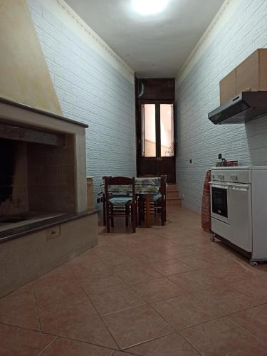 a kitchen with a stove and a table with chairs at Meraviglie Salentine in Lequile