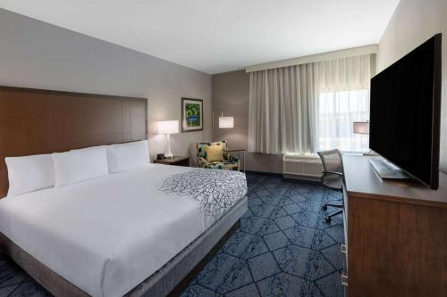 a hotel room with a bed and a flat screen tv at La Quinta Inn & Suites by Wyndham Round Rock near Kalahari in Round Rock
