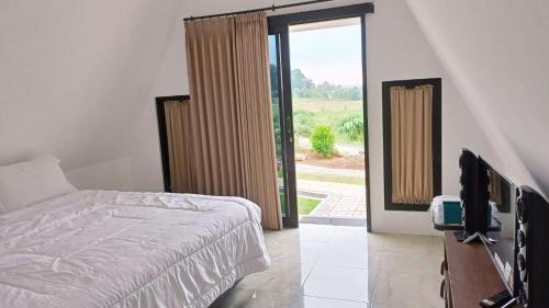 A bed or beds in a room at Joglo Kumpul Resort