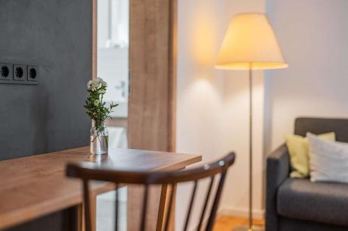 a table with a vase of flowers on it with a lamp at Gasthof Krone in Kinding