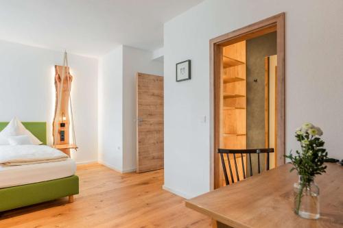 a living room with a table and a room with a bed at Gasthof Krone in Kinding