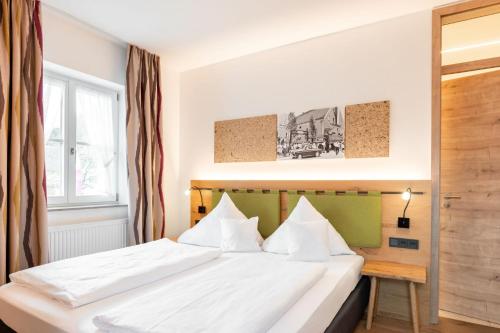 a bedroom with a large white bed with white pillows at Gasthof Krone in Kinding