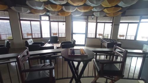 a waiting room with tables and chairs and windows at Polo Cherrapunjee Resort in Cherrapunji