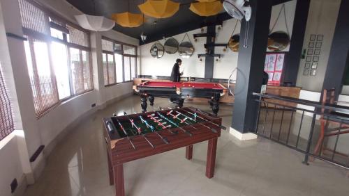 a man standing in a room with a pool table at Polo Cherrapunjee Resort in Cherrapunji