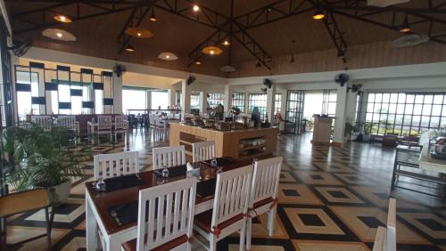 a restaurant with white chairs and tables in a room at Polo Cherrapunjee Resort in Cherrapunji