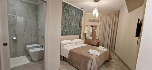 a bedroom with a bed and a bathroom with a shower at Hotel Sole in Gela