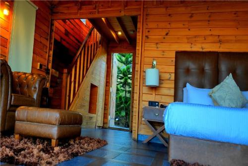 a bedroom with a bed and a chair at Polo Cherrapunjee Resort in Cherrapunji