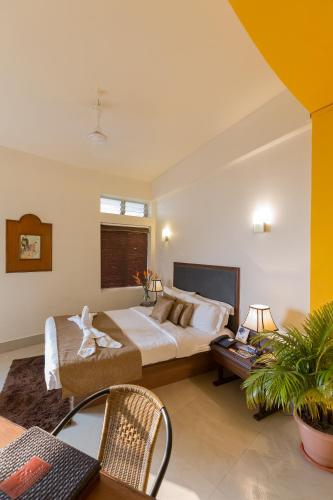 a bedroom with a large bed and a table and chairs at Polo Cherrapunjee Resort in Cherrapunji