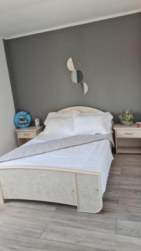 a bedroom with a white bed and two night stands at Vila Mondi in Eforie Nord
