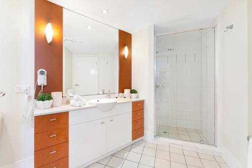 a bathroom with a sink and a shower at Iconic Chevron Renaissance Resort in Gold Coast