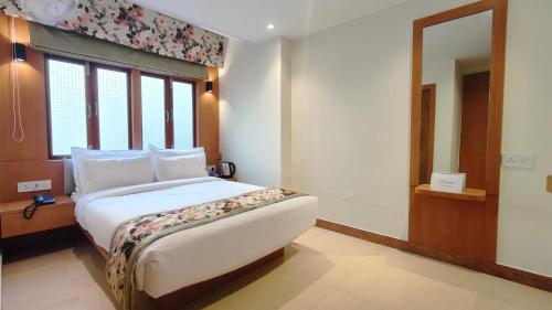 a bedroom with a bed and a large window at Mount Polaris Suites & Spa in Kalimpong