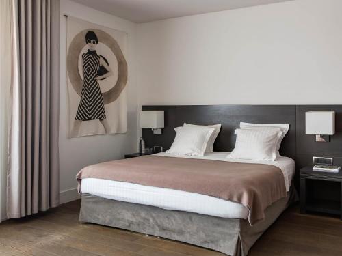 - une chambre avec un grand lit et une peinture d'une femme dans l'établissement New Hotel of Marseille - Vieux Port, à Marseille