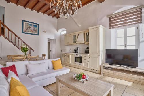 a living room with a white couch and a television at Myconian Princess in Mýkonos City