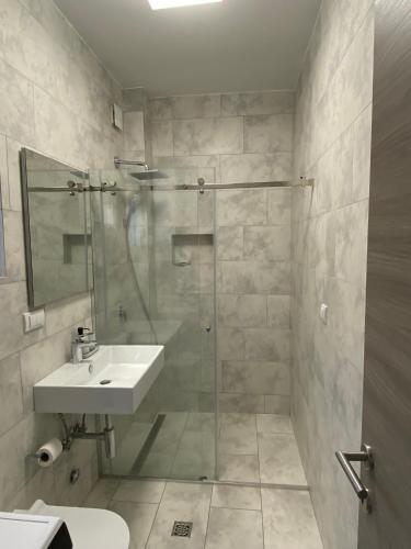 a bathroom with a sink and a glass shower at Infinity Panorama Apartment in Tivat