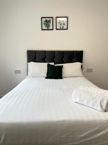 een groot wit bed met een zwart hoofdeinde in een slaapkamer bij Burleigh House - 3 Bed House in Leicester