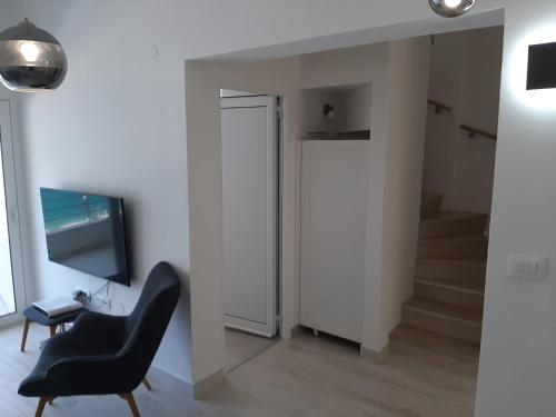 ein Wohnzimmer mit einem Stuhl und einem TV in der Unterkunft Luxury flat with amazing view INES in Kotor