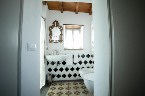 a bathroom with a sink and a toilet and a mirror at Corte Signoretti - Hystorical Villa in Canale Monterano