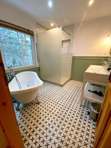 a bathroom with a tub and a shower and a sink at Chata Paradise in Smižany