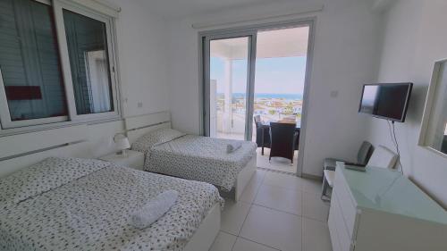 a hotel room with two beds and a television at STAY Kapparis View Apartment in Paralimni