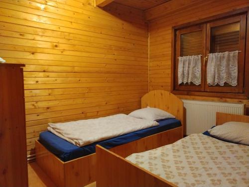 a room with two beds in a log cabin at Cabana BEY-KAY in Lacu Rosu