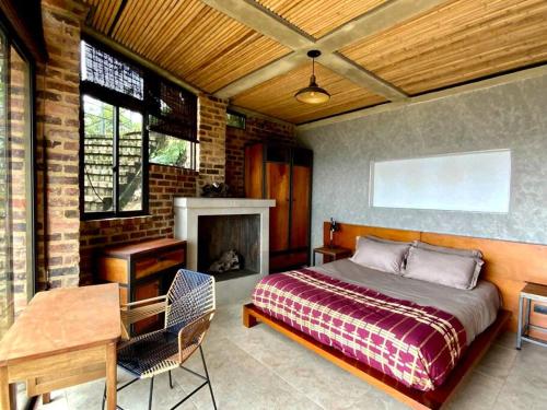 1 dormitorio con cama, mesa y chimenea en Suite en las Nubes Hotel Portal 360 en Nocaima