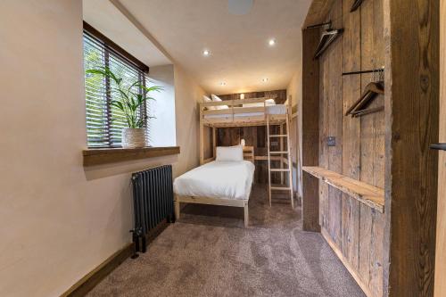 Habitación pequeña con cama y ventana en Luxury, newly renovated coach house with large private garden and hot tub en Windermere