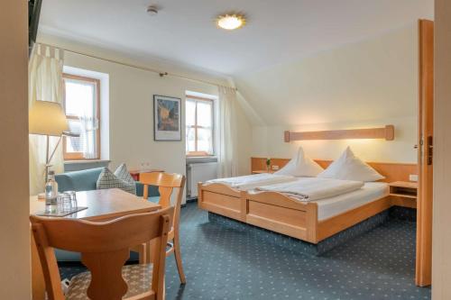 a hotel room with a bed and a table at Gasthof Krone in Kinding