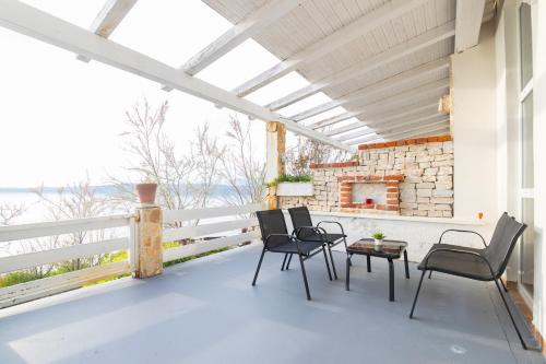 a patio with chairs and a table and a fireplace at Hotel Rooms Roccia in Novigrad Dalmatia