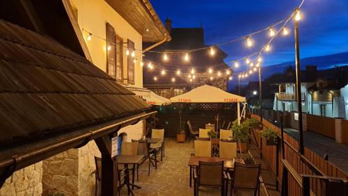 an outdoor patio with tables and chairs and lights at Pensjonat Pod Wietrzną Górą in Kazimierz Dolny