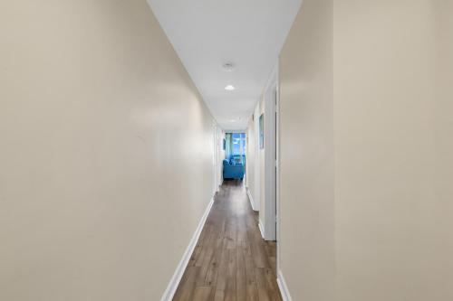 an empty hallway with white walls and wooden floors at Beachfront Condo in Atlantica Resort with Pool in Myrtle Beach