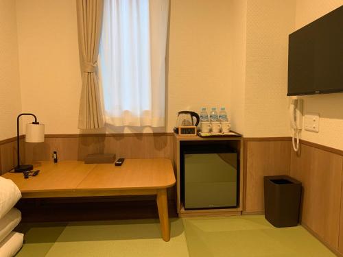 - une chambre avec une table et un banc dans l'établissement 若 京都河原町ホテル Waka Kyoto Kawaramachi Hotel, à Kyoto