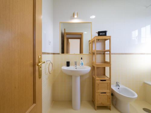 a bathroom with a sink and a mirror and a toilet at Private Terrace Majanicho Home -Garden & Pool in La Oliva