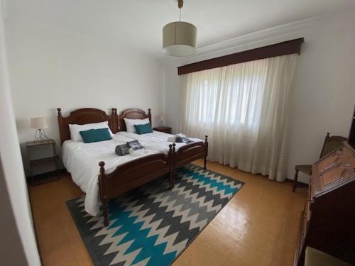 - une chambre avec un grand lit et un tapis dans l'établissement Casa Gorjão, à Anadia
