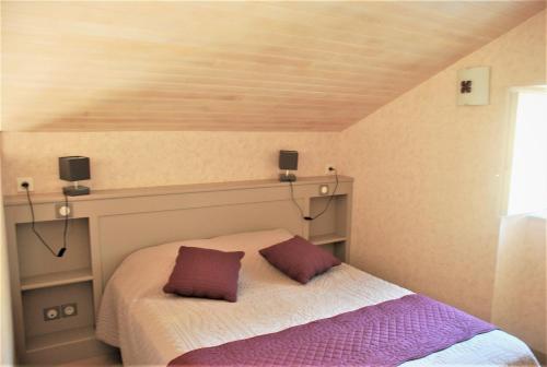 une chambre avec un lit avec deux oreillers dessus dans l'établissement COQUETTE MAISON, à Tocane-Saint-Apre