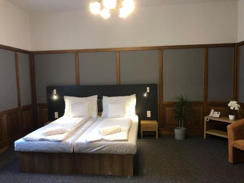 a bedroom with a bed with white sheets and pillows at Svájci Lak Panzió in Nyíregyháza