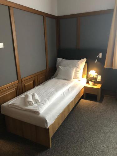 a bed with two towels on it in a bedroom at Svájci Lak Panzió in Nyíregyháza