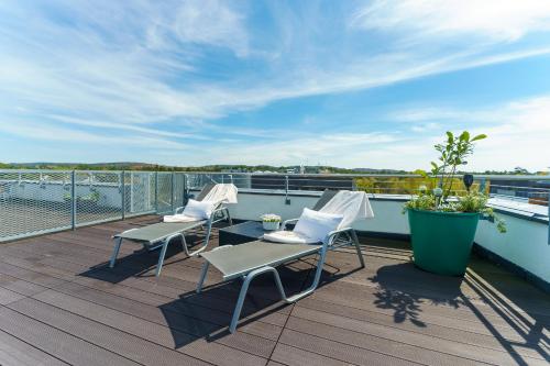 ミエンジズドロイェにあるW Rent like home - Tulipan Penthouse IIIの3脚の椅子とテーブル、景色を望むバルコニー
