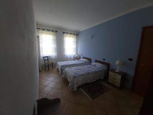 a bedroom with two beds and a table and a chair at Cascina Cantaret Agriturismo in Agliano Terme
