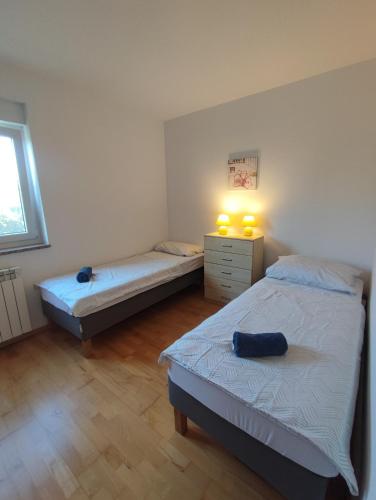 a bedroom with two beds and a window and two lamps at Villa Maya in Ližnjan