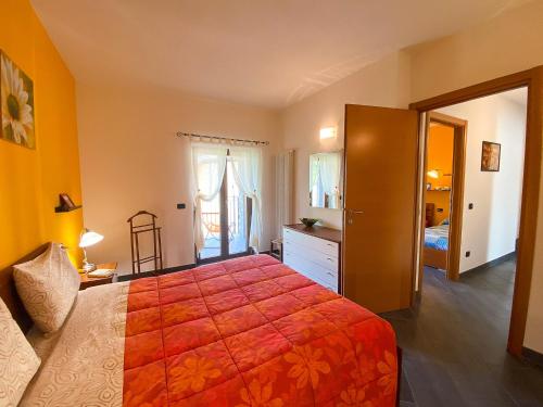 韦尔卡纳Giardino di Maria - Tulipano Panoramawohnung (OG)的卧室里有一张大床，上面铺着红毯子