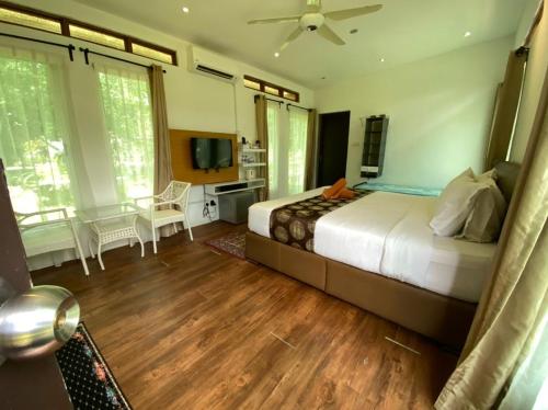 ein Schlafzimmer mit einem großen Bett und einem TV in der Unterkunft Sailor's Rest in Janda Baik