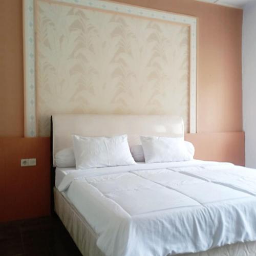 CampakaにあるSurga Dirga Resortのベッドルーム1室(オレンジ色の壁の白いベッド1台付)