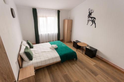 a bedroom with a bed and a deer on the wall at Vila Haiduk in Runcu