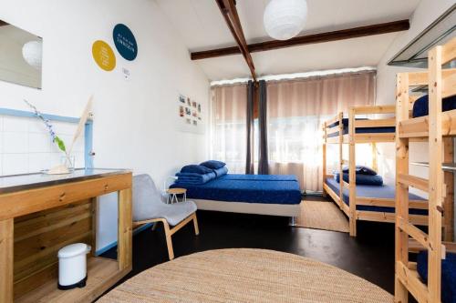 Cette chambre comprend deux lits superposés et un bureau. dans l'établissement Het Toppunt groot vakantiehuis aan het water, à Sneek