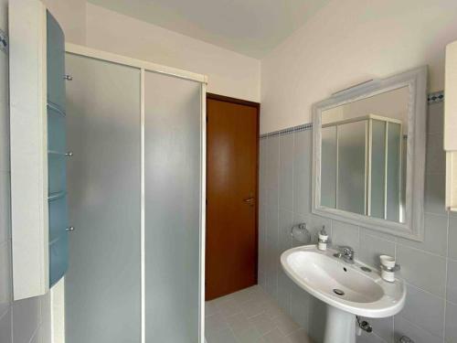 y baño con lavabo, espejo y ducha. en [Vista lago]-Appartamento funzionale con vista, en Varese