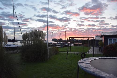 a sunset over a marina with boats in the water at Het Toppunt groot vakantiehuis aan het water in Sneek