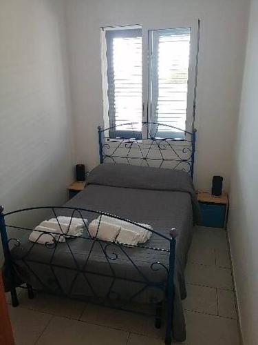 a bed in a room with a window at Villa Sunshine in Triscina