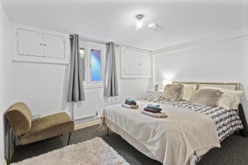biała sypialnia z łóżkiem i krzesłem w obiekcie Maidstone Best 1 Bed City Centre Flat - Fast Wi-Fi w mieście Maidstone